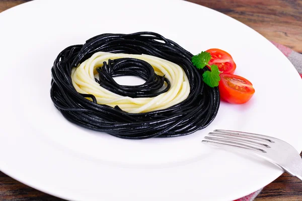 Černé špagety s inkoustem sépie, rajčaty a bazalkou. Mediterra — Stock fotografie