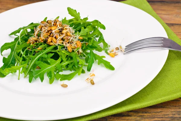 Rucola salade met gekiemd graan in witte plaat — Stockfoto