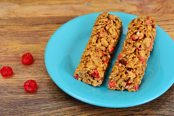 Muesli bars with sunflower seeds, nuts and dried cherrieson Wood — Stock Photo, Image