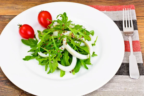 Ensalada de rúcula con calamares, semillas de lino, aceitunas y tomates cherry —  Fotos de Stock