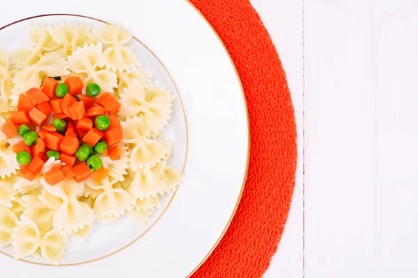 Arco de pasta con zanahorias picadas, salami y guisantes verdes — Foto de Stock