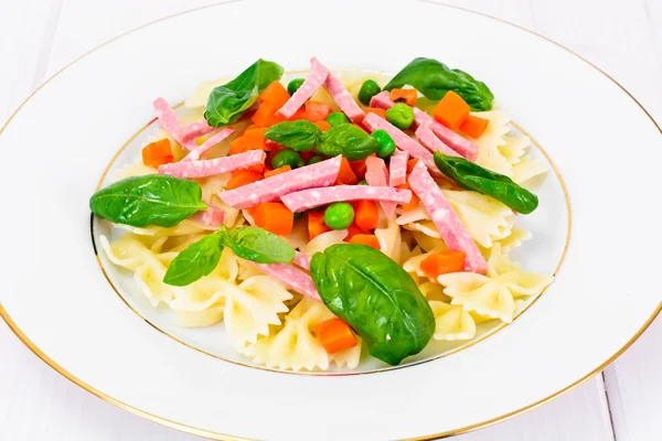 Arco de pasta con zanahorias picadas, salami y guisantes verdes — Foto de Stock