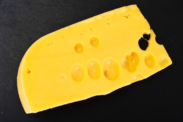 Schweizer Käse isoliert auf schwarzem Hintergrund — Stockfoto