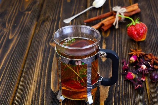 Té de hierbas con tomillo, menta y canela en respaldo rústico de madera —  Fotos de Stock