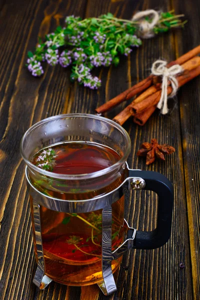 Té de hierbas con tomillo, menta y canela en respaldo rústico de madera — Foto de Stock