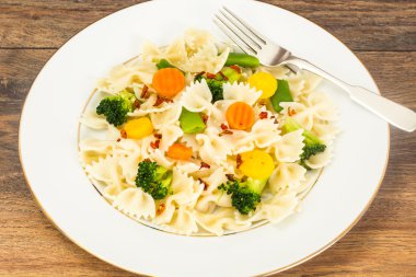 Farfalle havuç, fasulye, brokoli ve sosis ile