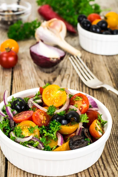Vegetarischer Salat aus Kirschtomaten, schwarzen Oliven und roten Zwiebeln — Stockfoto