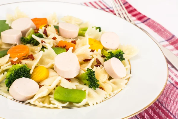 Farfalle con zanahorias, frijoles, brócoli y salchichas — Foto de Stock