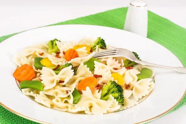 Farfalle con zanahorias, frijoles, brócoli y salchichas — Foto de Stock