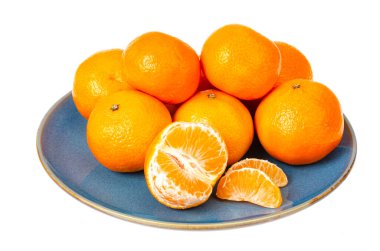 Beyaz arka planda parlak turuncu mandalinalı mavi plaka. Fotoğraf.