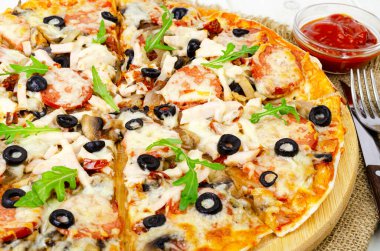 Salamlı pizza, jambon ve ahşap masada mozzarella.