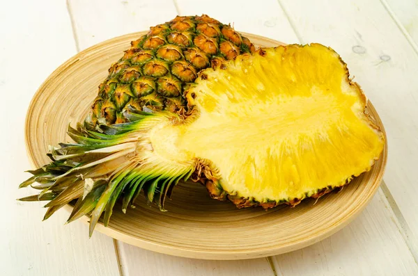 Egzotik meyveler. Ahşap zemin üzerinde olgun, olgun bir ananas. Fotoğraf.