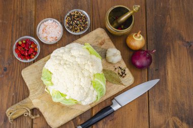 Lahana başı taze organik karnabahar ahşap arka planda, baharatlar.