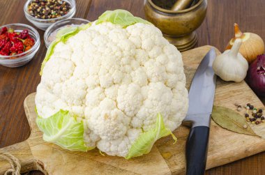 Lahana başı taze organik karnabahar ahşap arka planda, baharatlar.