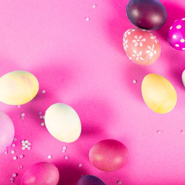 Pembe arka planda Paskalya yumurtaları olan renkli bir arka plan. Mutlu Paskalyalar. Poster, geçmiş ya da tatil kartı olarak kullanılabilir. Düz konum, üst görünüm, kopyalama alanı.