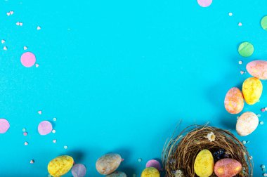 Mavi arka planda Paskalya yumurtaları olan renkli bir arka plan. Mutlu Paskalyalar. Poster, geçmiş ya da tatil kartı olarak kullanılabilir. Düz konum, üst görünüm, kopyalama alanı.