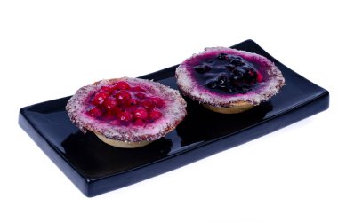 Beyaz arka planda tatlı böğürtlen ve jöle dolu kum sepetleri. Fotoğraf.