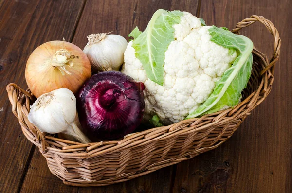 Basket with organic vegetables, cauliflower, onion, garlic. Farm products. Studio Photo