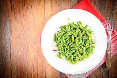 Beyaz bir plaka üzerinde sarımsaklı kızarmış yeşil fasulye