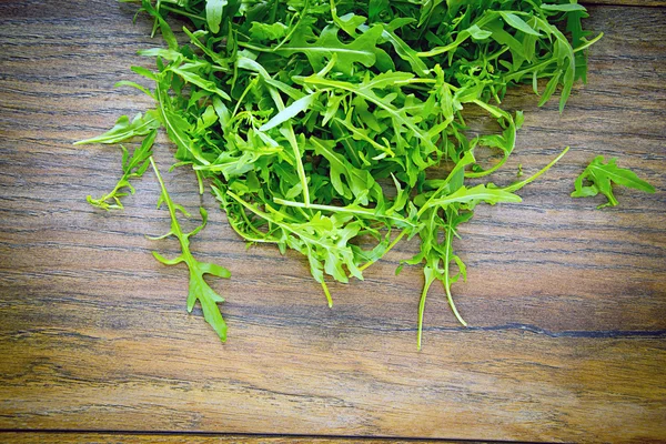 Arugula em fundo lenhoso escuro — Fotografia de Stock