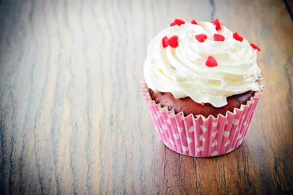 Kuchen mit Sahne, Cupcake auf holzigem Hintergrund — Stockfoto