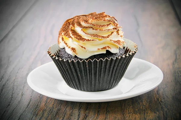 Tarta con crema, magdalena sobre fondo leñoso — Foto de Stock