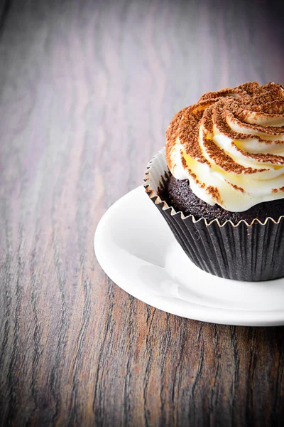 Tarta con crema, magdalena sobre fondo leñoso — Foto de Stock