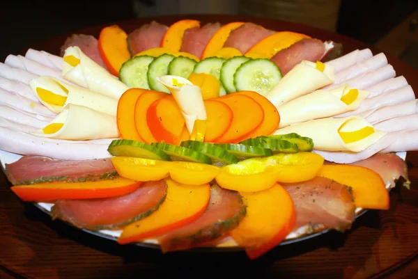 Em uma placa de pedaços fatiados de carne e legumes: Pepinos, B — Fotografia de Stock
