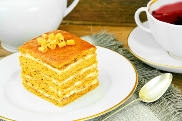 Kuchen mit Kondensmilch, Nüssen und Honig. Tee, Geschirr. — Stockfoto