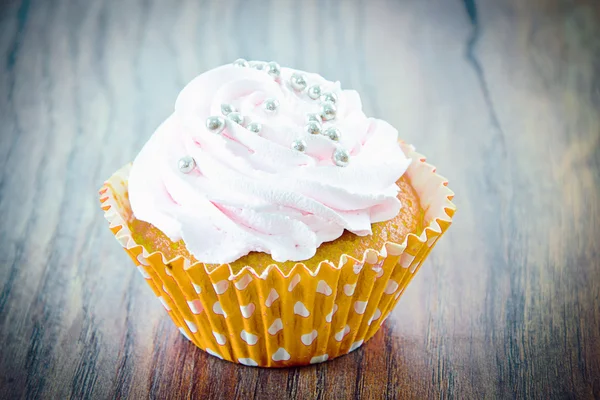 Kuchen mit Sahne, Cupcake auf holzigem Hintergrund. — Stockfoto