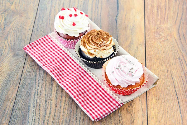 Kuchen mit Sahne, Cupcake auf holzigem Hintergrund. — Stockfoto