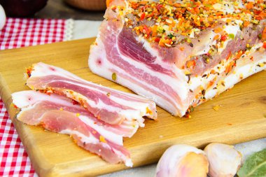 Tuzlanmış domuz yağı, ahşap kesme tahtası üzerinde baharatlar ile çiğ domuz eti