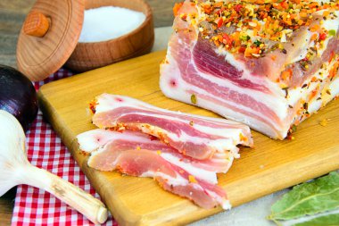 Tuzlanmış domuz yağı, ahşap kesme tahtası üzerinde baharatlar ile çiğ domuz eti