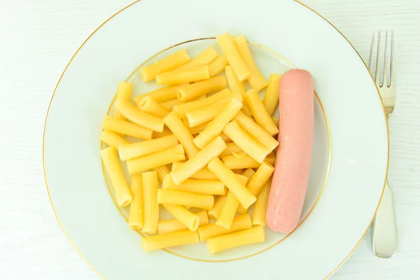 Fast Food essen: Pasta mit Wurst auf dem Teller. — Stockfoto