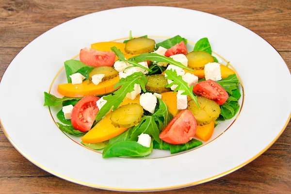 Здоровая и диетическая пища: салат, хурма, маринованный огурец, помидор — стоковое фото