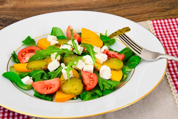 Gesundes und diätetisches Essen: Salat, Kaki, eingelegte Gurken, Tomaten — Stockfoto