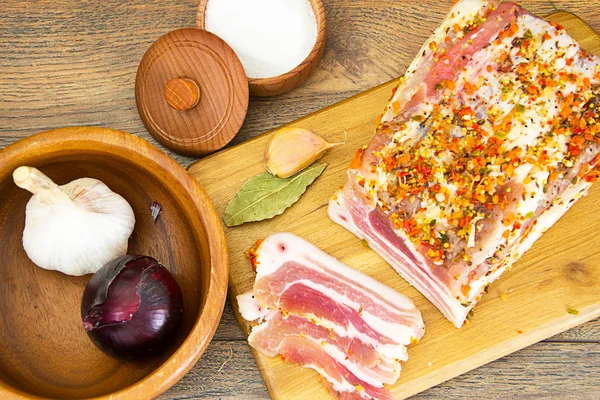 Lardo salado, cerdo crudo con especias en tabla de cortar de madera — Foto de Stock