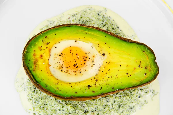 Avocados, baked with quail egg, salt, pepper, lemon