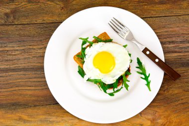 Bütün tahıl ekmeği üzerinde roka ile pişmiş yumurta