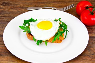 Bütün tahıl ekmeği üzerinde roka ile pişmiş yumurta