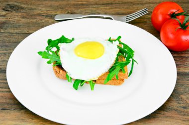 Bütün tahıl ekmeği üzerinde roka ile pişmiş yumurta