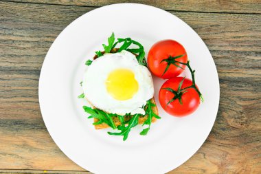 Bütün tahıl ekmeği üzerinde roka ile pişmiş yumurta