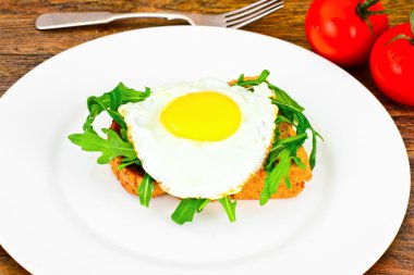 Bütün tahıl ekmeği üzerinde roka ile pişmiş yumurta