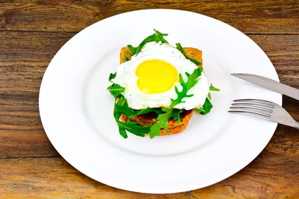 Œufs brouillés avec roquette sur pain de grains entiers — Photo