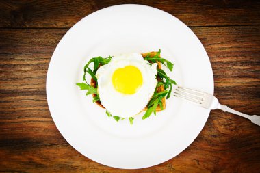 Bütün tahıl ekmeği üzerinde roka ile pişmiş yumurta