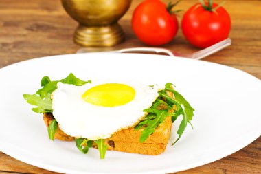 Bütün tahıl ekmeği üzerinde roka ile pişmiş yumurta