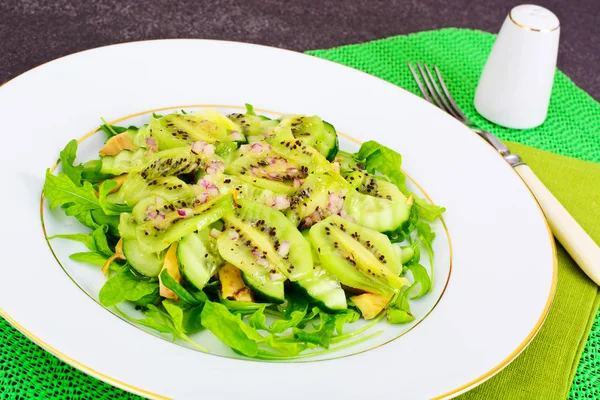 Salade de roquette, kiwi et concombre sur assiette blanche — Photo