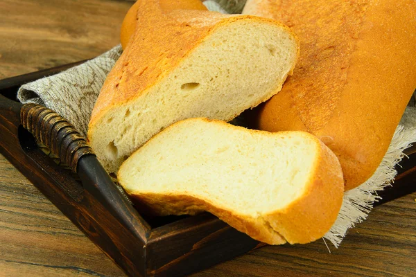 Pão saboroso fresco em fundo lenhoso — Fotografia de Stock