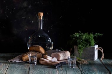 Durgun hayat. Domuz yağı, ev yapımı votka, yeşil soğan, ahşap bir masa üzerinde dereotu ve ekmek (Ukrayna ve Rus ulusal aperatifi)
