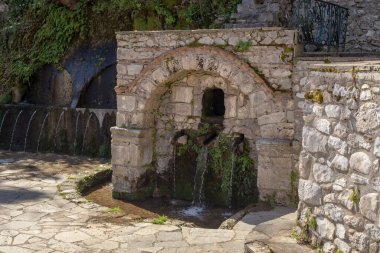 Güneşli bir bahar gününde Parorio (Laconia, Moreloponnese, Yunanistan) köyünde temiz, lezzetli ve temiz suya sahip taş kaynaklar
